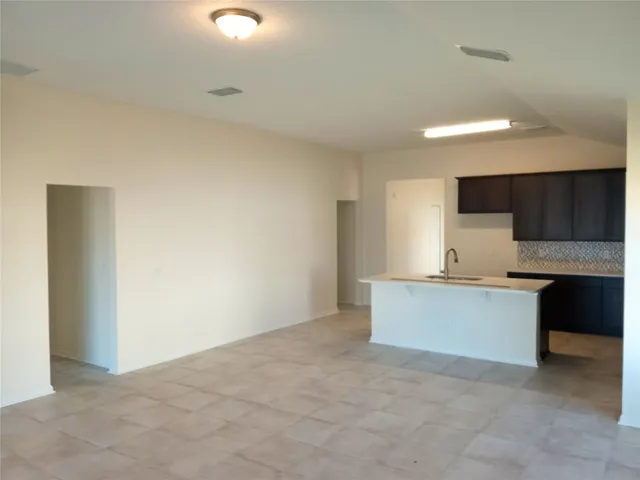 a large white kitchen with a stove a sink and dishwasher