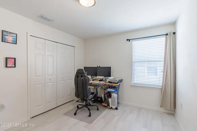 a view of a workspace with furniture and a window
