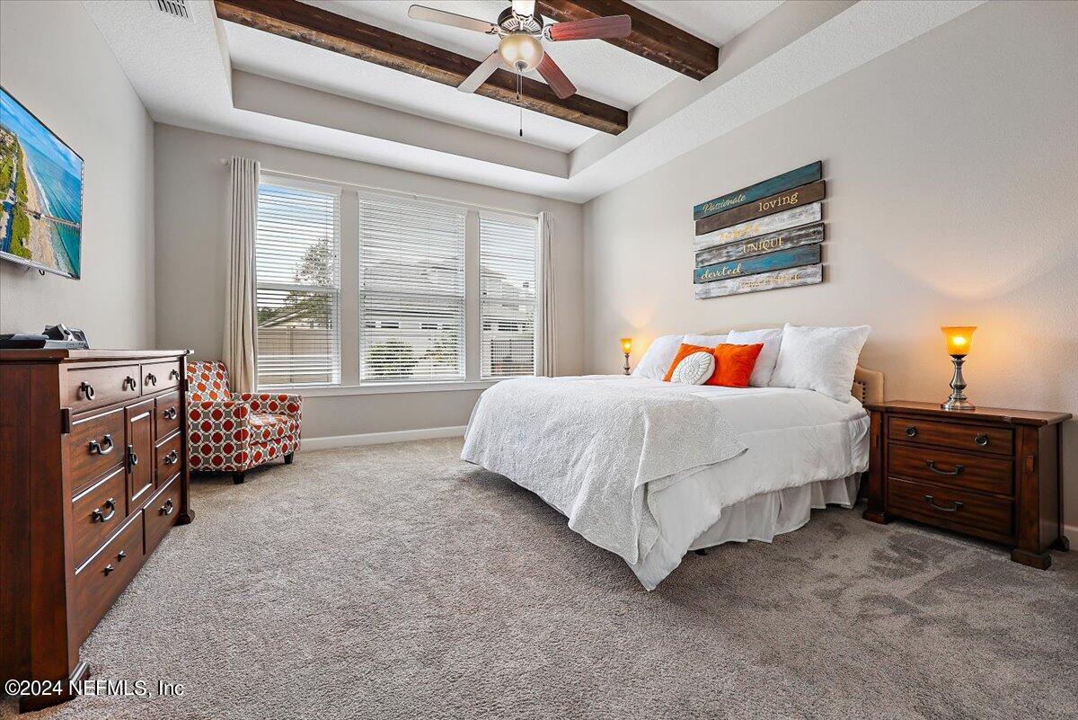 778 Glenneyre Circle St. Augustine, FL 32092 - Photo 11 of 40 a spacious bedroom with a bed and a chandelier