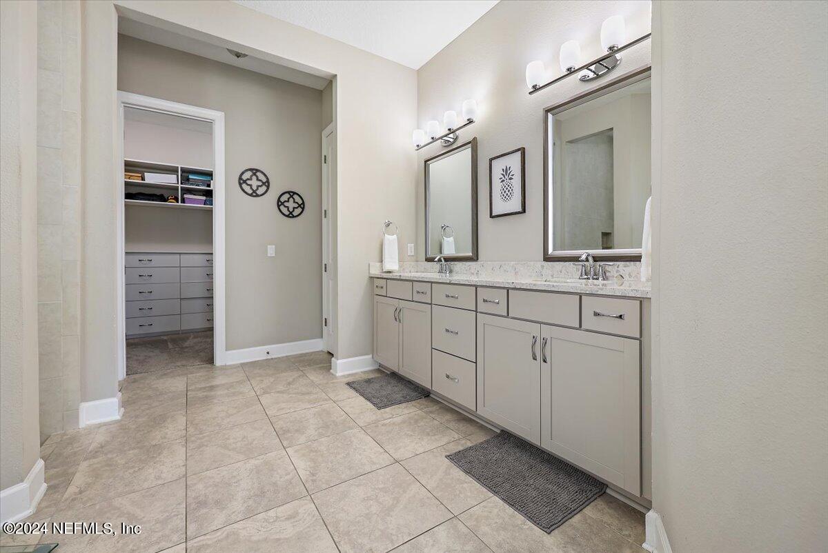 778 Glenneyre Circle St. Augustine, FL 32092 - Photo 12 of 40 a spacious bathroom with a granite countertop sink a mirror and a vanity