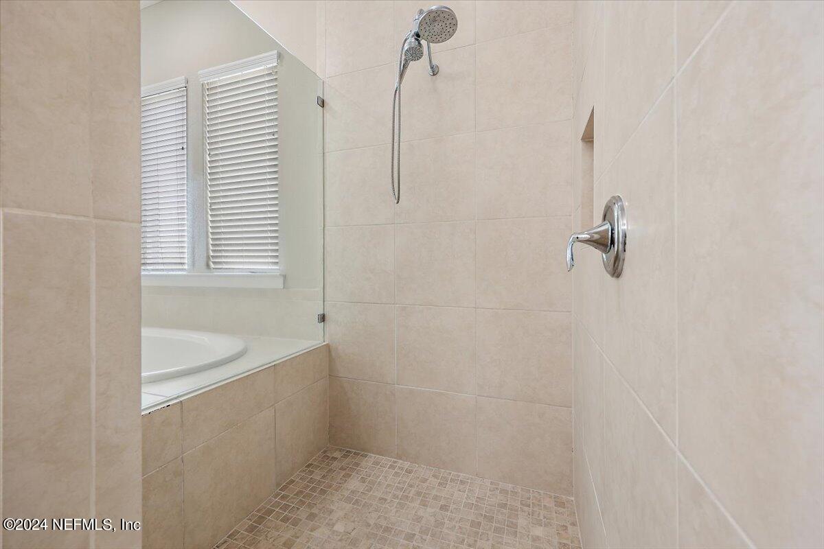 778 Glenneyre Circle St. Augustine, FL 32092 - Photo 14 of 40 a bathroom with a tub a sink and window