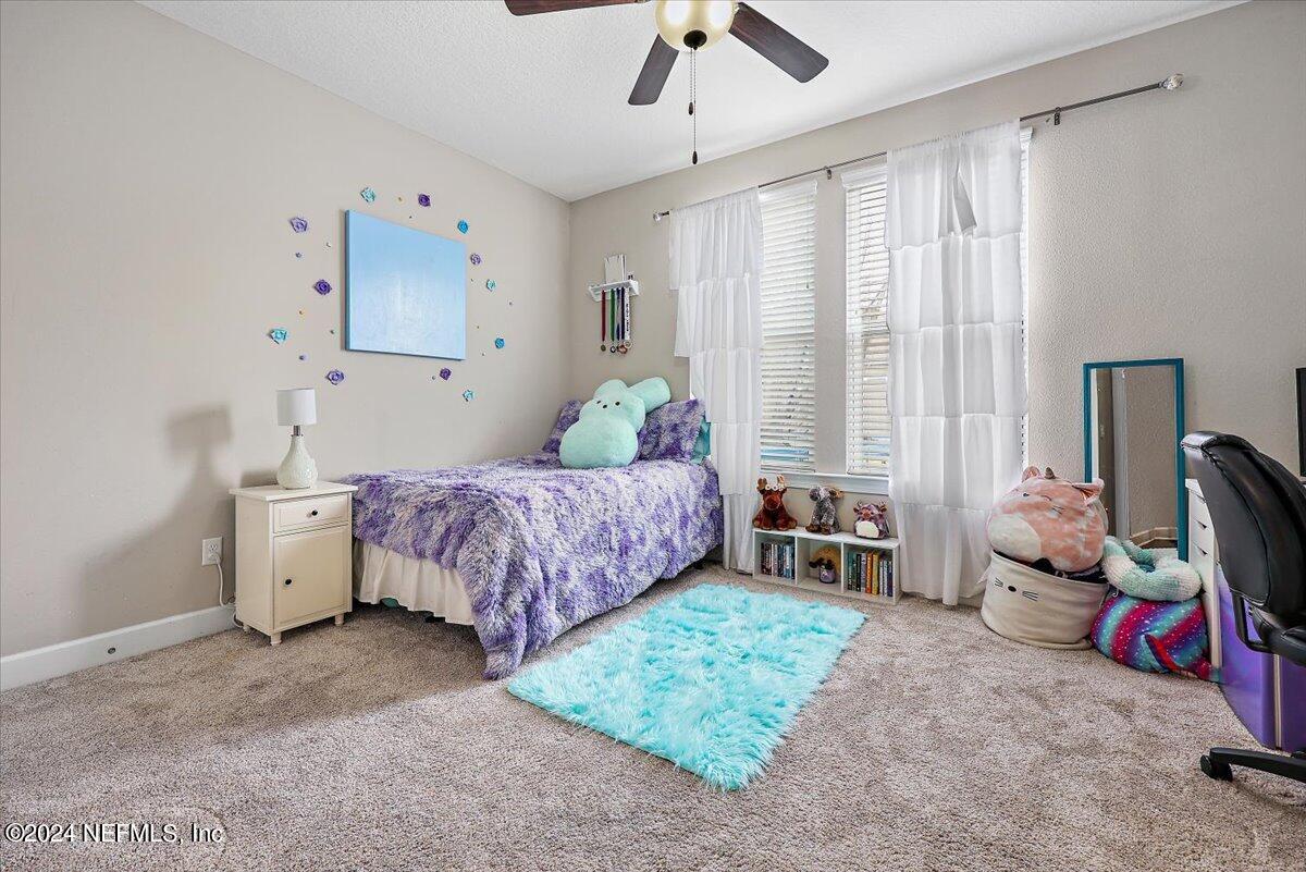 778 Glenneyre Circle St. Augustine, FL 32092 - Photo 16 of 40 a bedroom with a bed and a chandelier