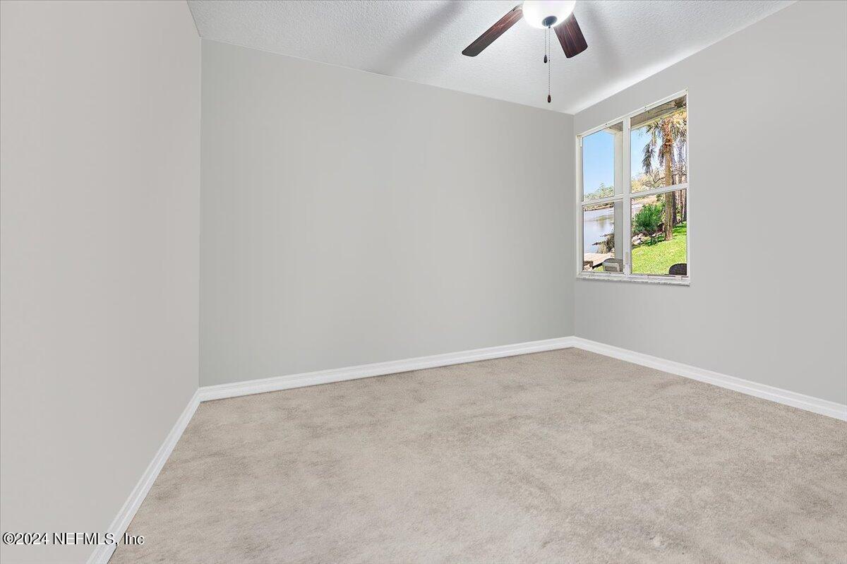 778 Glenneyre Circle St. Augustine, FL 32092 - Photo 18 of 40 an empty room with chandelier fan and windows
