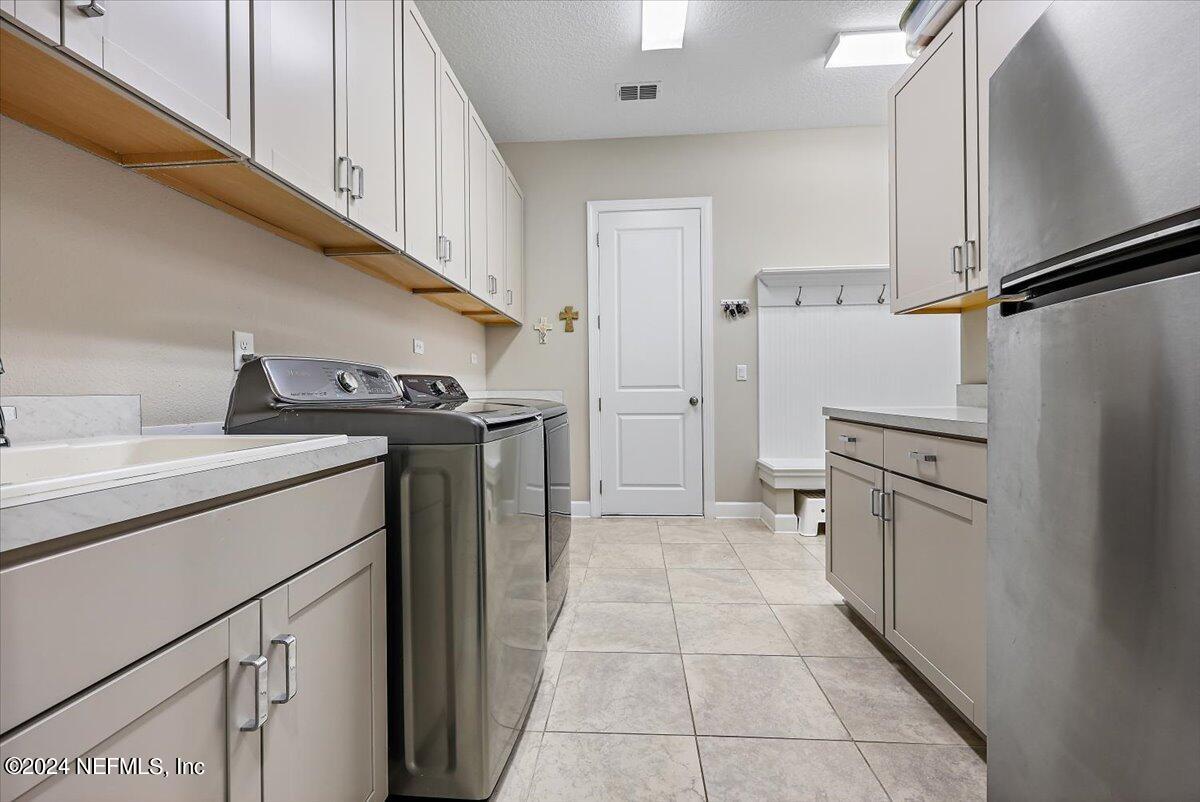 778 Glenneyre Circle St. Augustine, FL 32092 - Photo 21 of 40 a utility room with cabinets washer and dryer