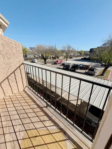 a view of balcony with wooden floor and fence