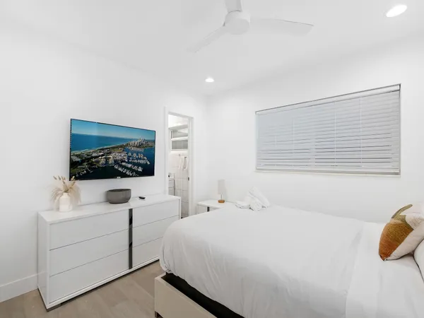 a bedroom with a bed and a large mirror