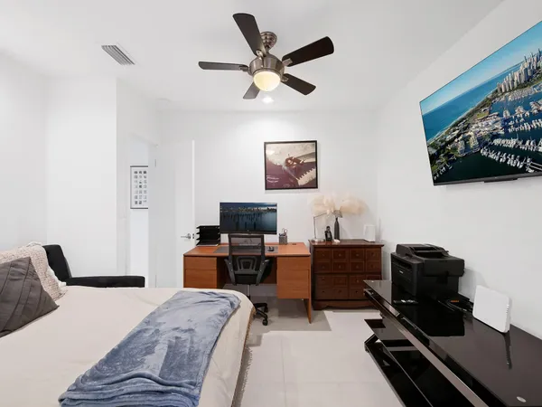 a room with stainless steel appliances kitchen island granite countertop a dining table chairs and a refrigerator