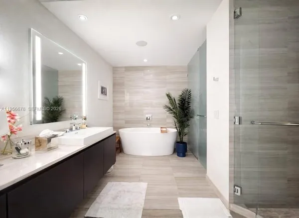 a bathroom with a double vanity sink bathtub and a large mirror