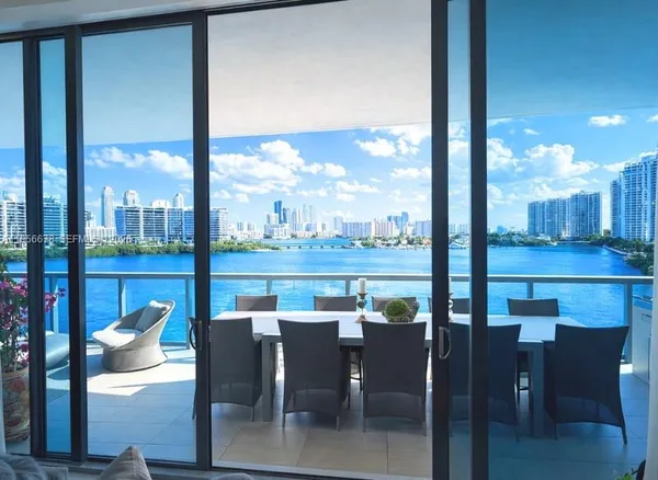 a dining room with furniture water view and a floor to ceiling window