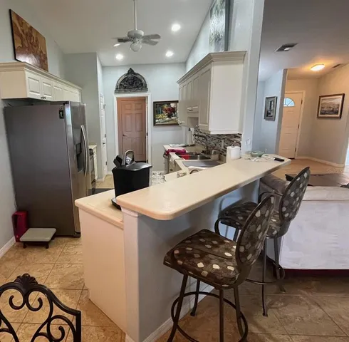 a dining room with furniture and a floor to ceiling window