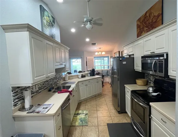 a living room with a large window and chandelier