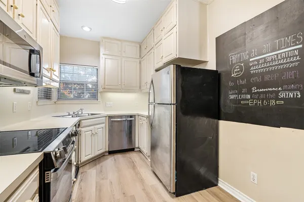a kitchen with stainless steel appliances granite countertop a refrigerator a stove and a sink