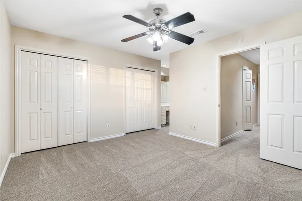 a view of an empty room with a ceiling fan
