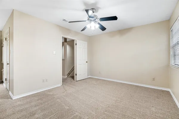an empty room with closet and windows