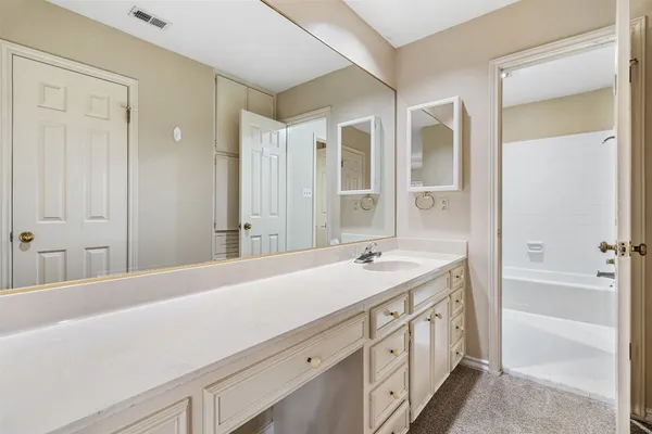 a spacious bathroom with a shower sink and mirror