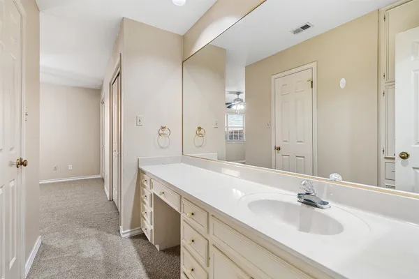 a spacious bathroom with a sink and a mirror