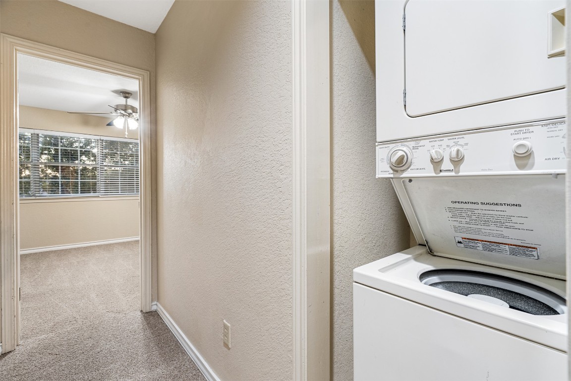 2408 Enfield Road, Unit 211 Austin, TX 78703 - Photo 26 of 26 Washroom with a textured wall, stacked washer / dryer, and light colored carpet