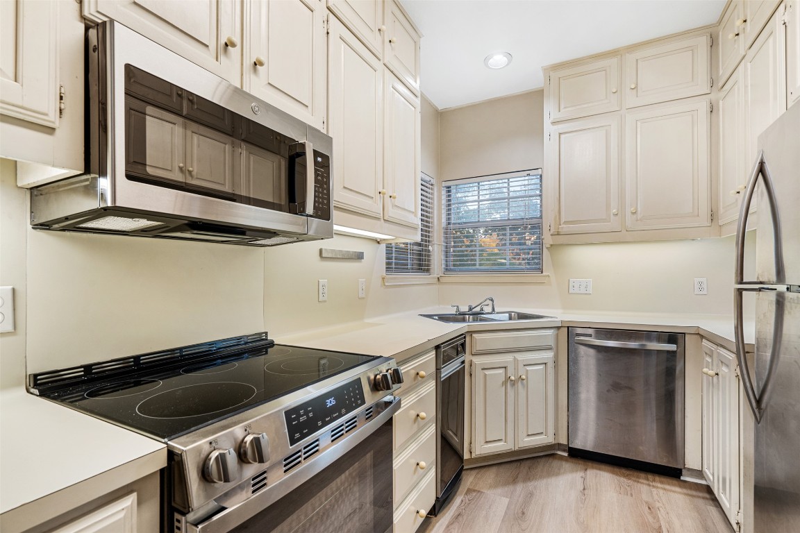 2408 Enfield Road, Unit 211 Austin, TX 78703 - Photo 10 of 26 Kitchen featuring stainless steel appliances, light countertops, and light wood-type flooring