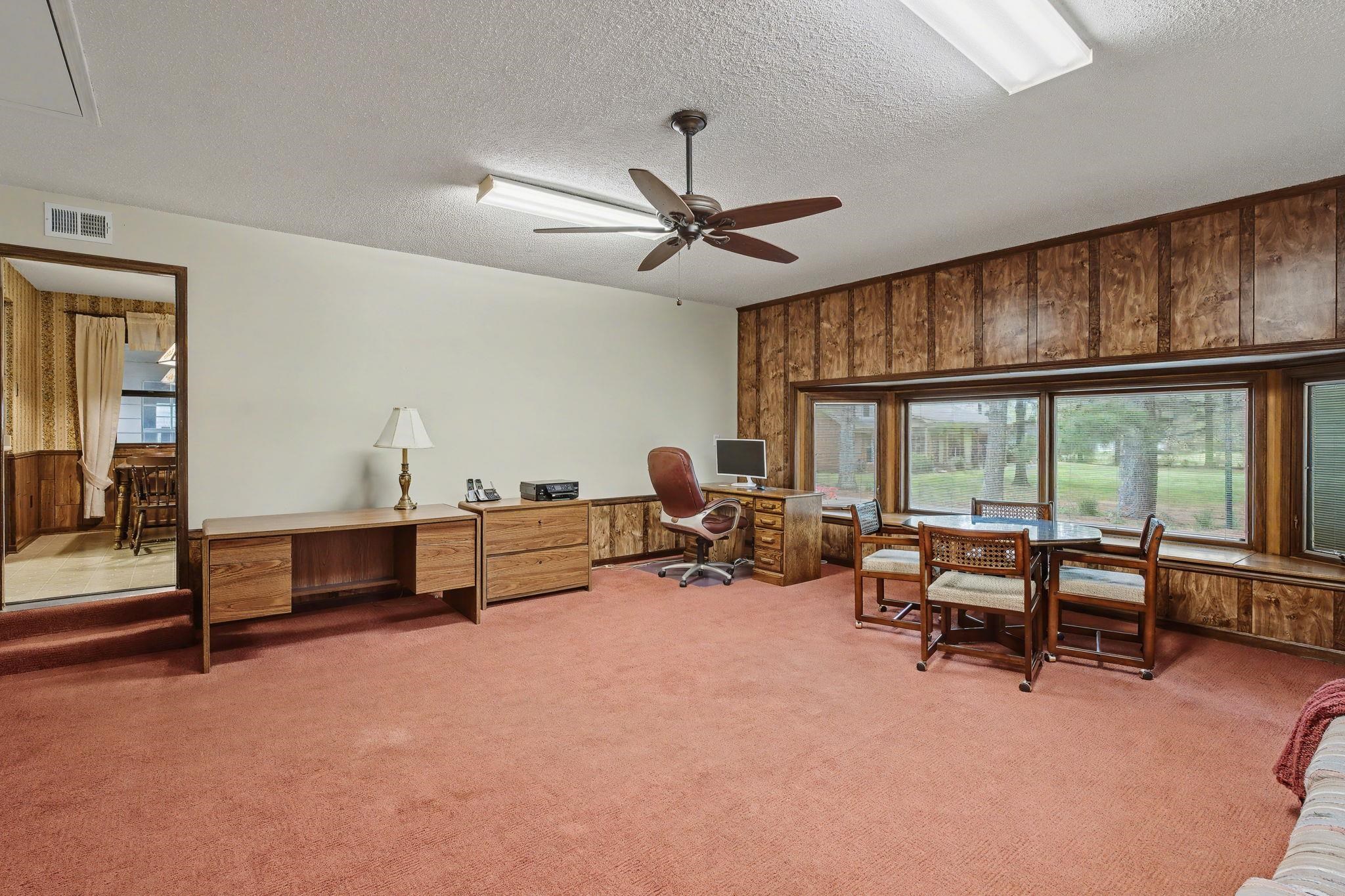11380 Sycamore Farms Road Collierville, TN 38017 - Photo 19 of 35 Home office featuring wood walls, light colored carpet, a ceiling fan, and a textured ceiling