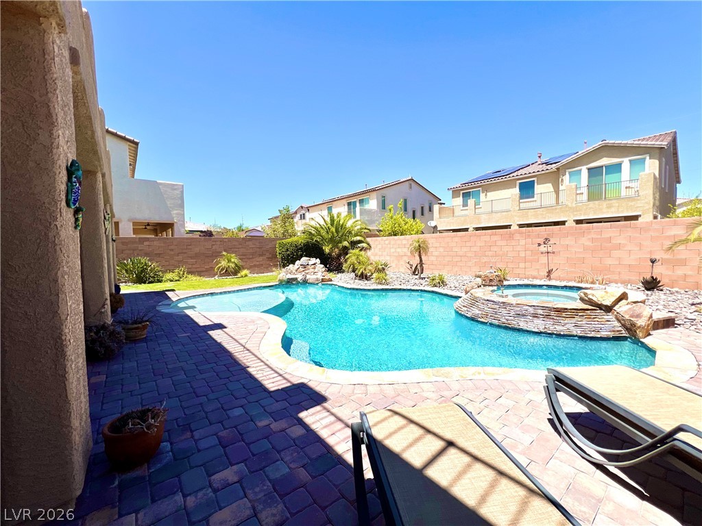 9724 University Ridge Avenue Las Vegas, NV 89149 - Photo 33 of 61 A private backyard oasis features a shimmering pool and spa, perfect for relaxation and entertaining.