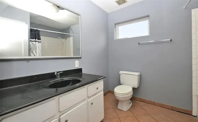 a bathroom with a toilet a sink and mirror