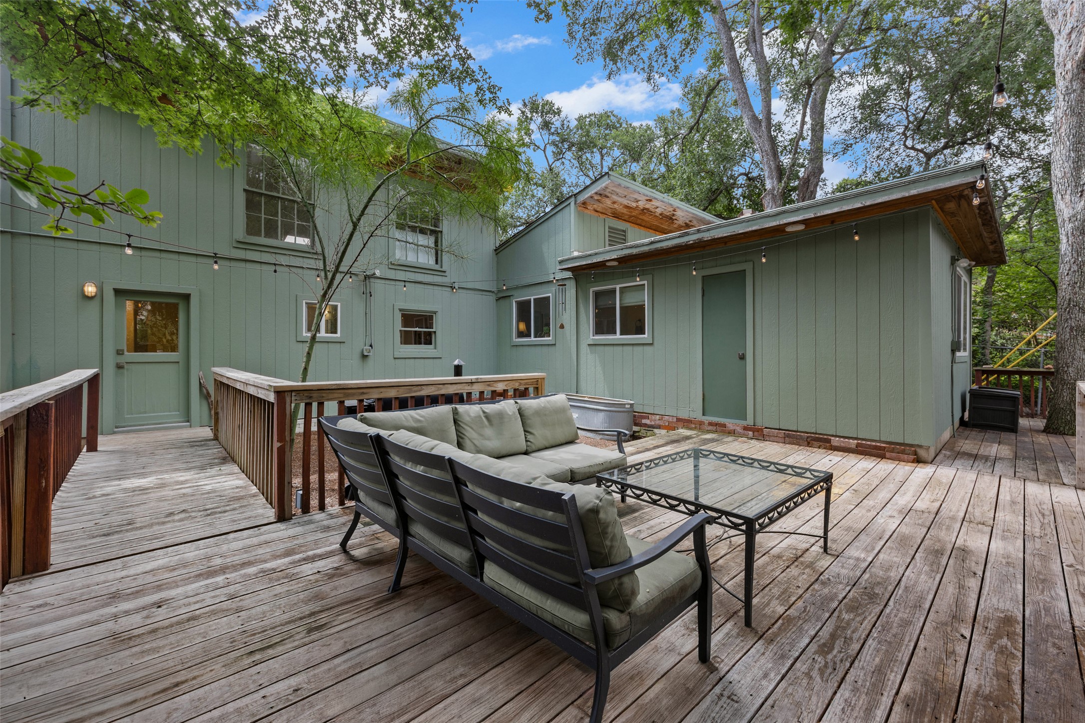 3302 Cherrywood Road Austin, TX 78722 - Photo 21 of 26 A spacious wooden deck provides ample outdoor living space, nestled among mature trees for privacy and entertaining.