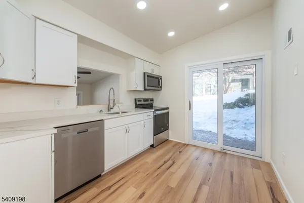 a kitchen with a sink window and stainless steel appliances