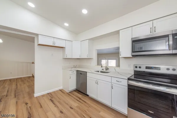 a kitchen with stainless steel appliances a sink cabinets and a stove top oven