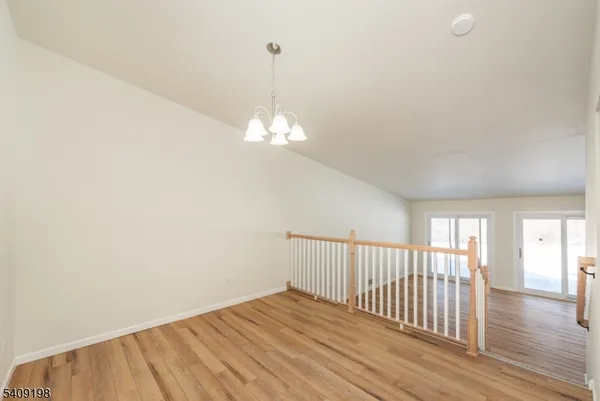 a view of a livingroom with wooden floor and chandelier