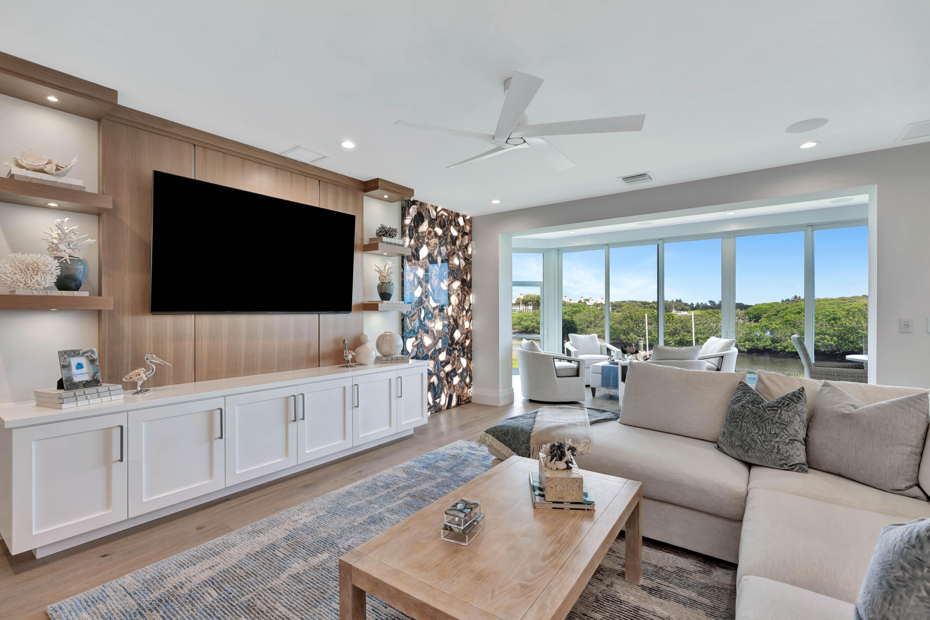 a living room with furniture a flat screen tv and a large window