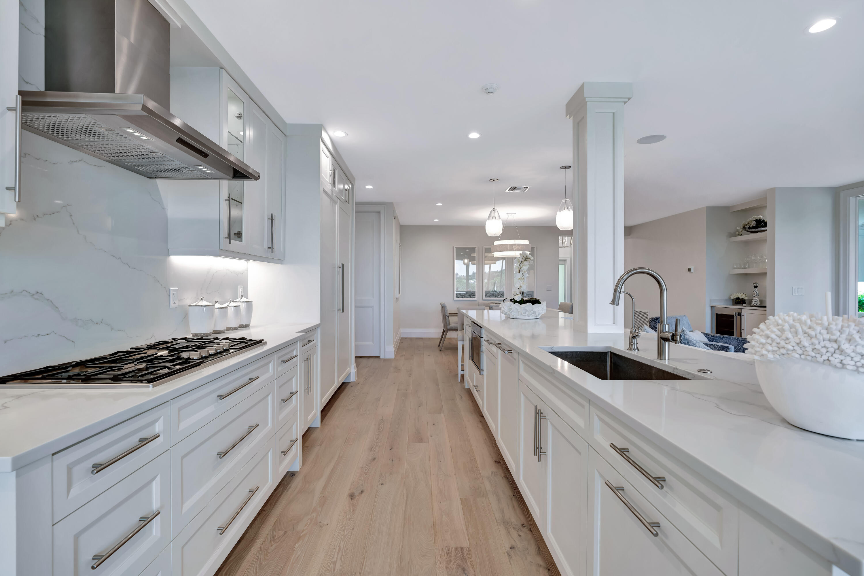 260 Eagle Drive Jupiter, FL 33477 - Photo 14 of 41 a large kitchen with stainless steel appliances a stove a sink dishwasher and white cabinets with wooden floor