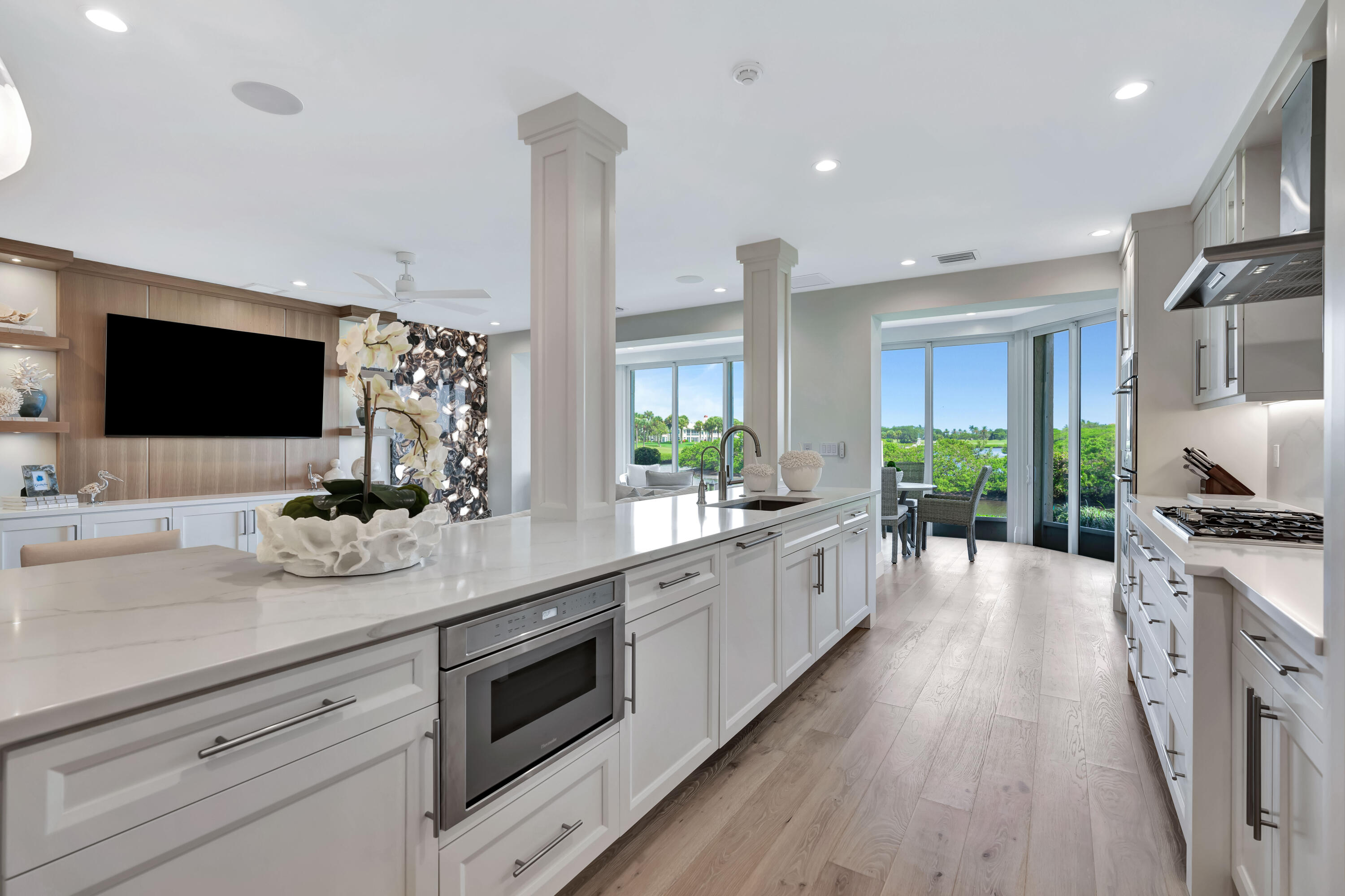 260 Eagle Drive Jupiter, FL 33477 - Photo 16 of 41 a large kitchen with stainless steel appliances kitchen island granite countertop a sink stove and white cabinets