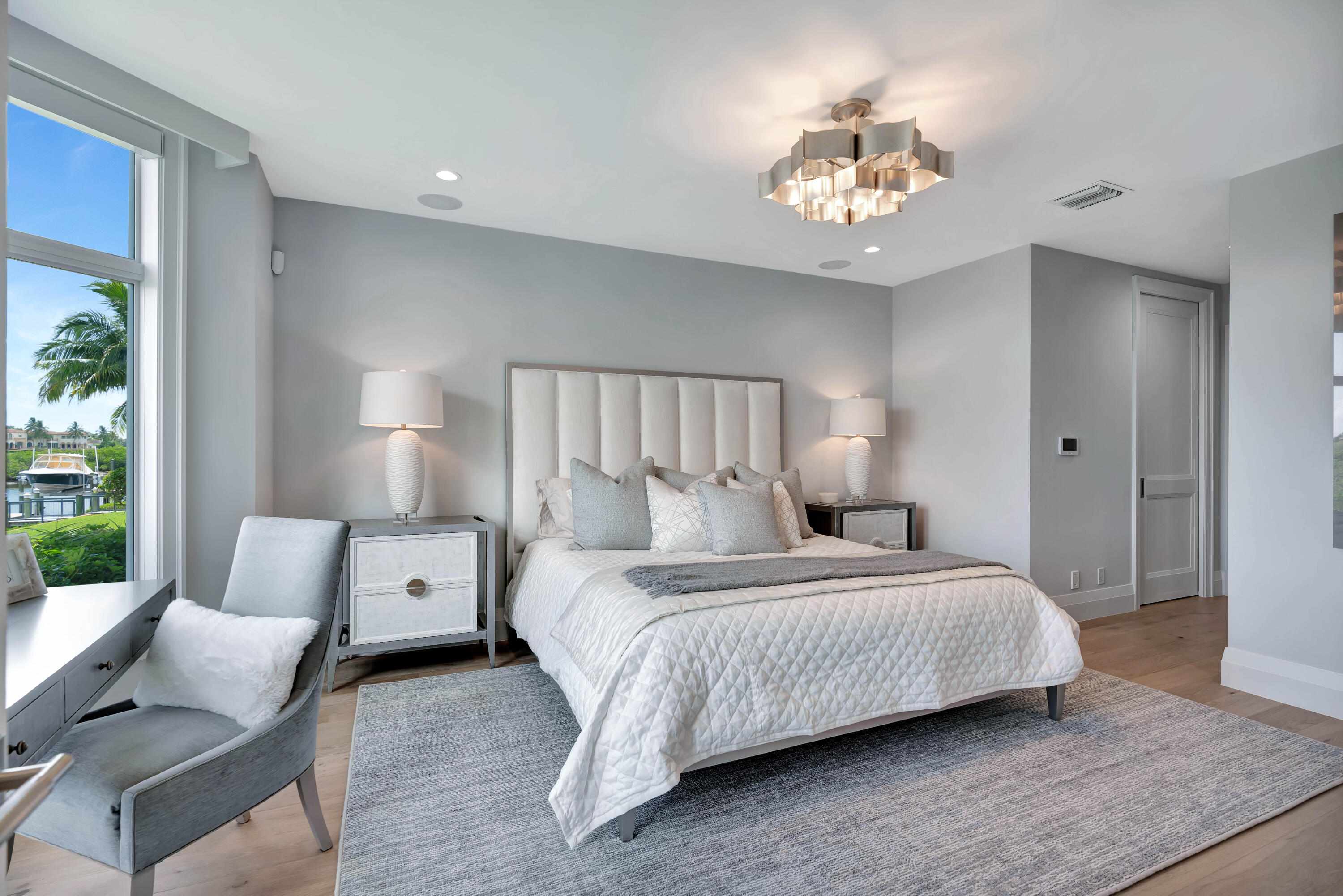 260 Eagle Drive Jupiter, FL 33477 - Photo 22 of 41 a bedroom with a large bed and a chandelier