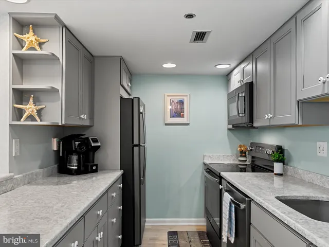 a kitchen with stainless steel appliances granite countertop a sink a stove and refrigerator