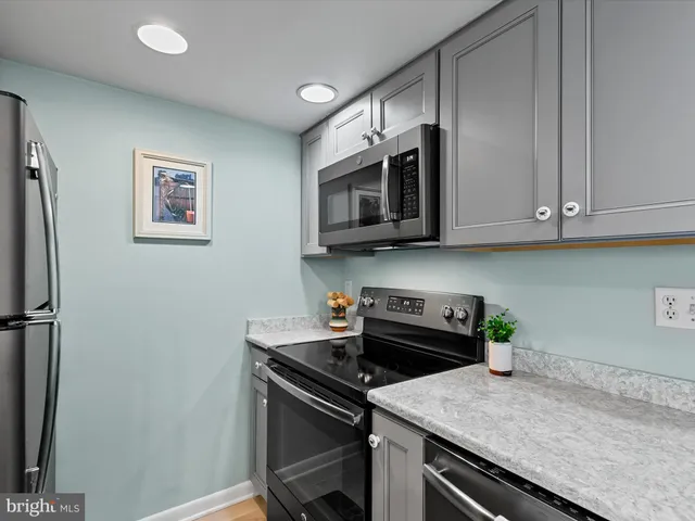 a kitchen with stainless steel appliances a stove microwave and refrigerator