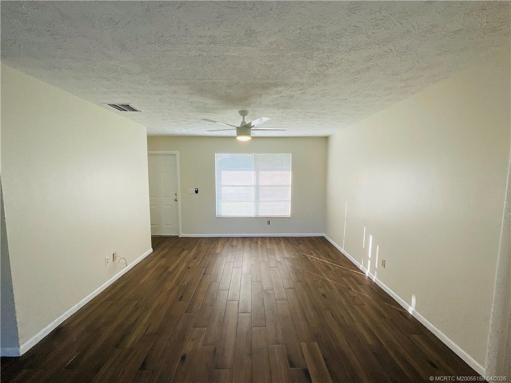 941 Southwest Fenway Road Port St. Lucie, FL 34953 - Photo 3 of 15 an empty room with wooden floor and windows