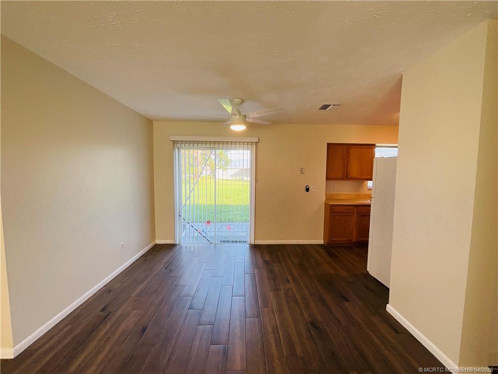 941 Southwest Fenway Road Port St. Lucie, FL 34953 - Photo 4 of 15 a view of a kitchen with a fridge and wooden floor