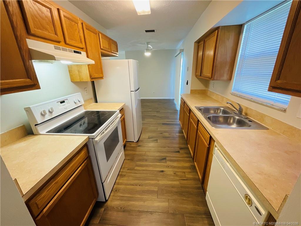 941 Southwest Fenway Road Port St. Lucie, FL 34953 - Photo 7 of 15 a kitchen with a sink a stove and refrigerator