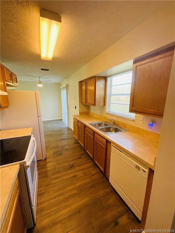 941 Southwest Fenway Road Port St. Lucie, FL 34953 - Photo 8 of 15 a kitchen with stainless steel appliances granite countertop a sink and wooden cabinets