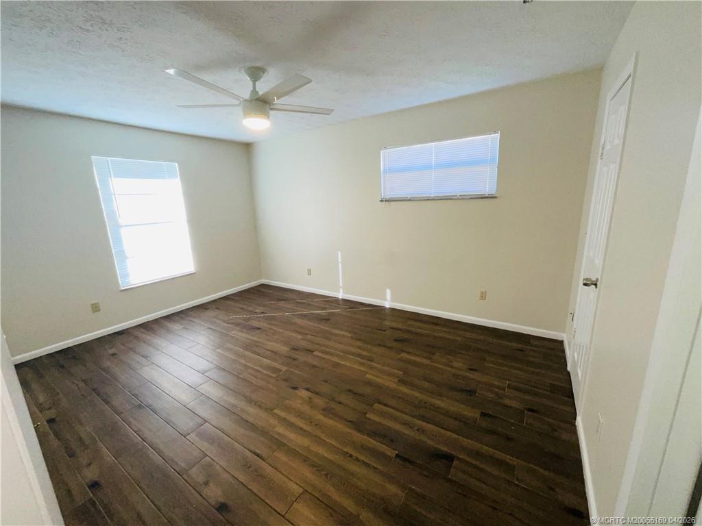 941 Southwest Fenway Road Port St. Lucie, FL 34953 - Photo 10 of 15 an empty room with wooden floor and windows