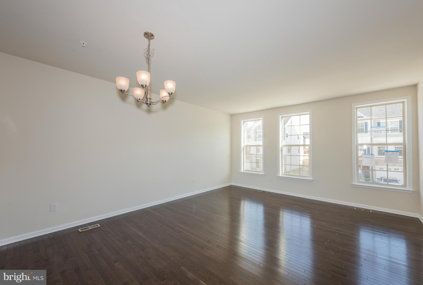 4716 Cambria Road Frederick, MD 21703 - Photo 2 of 27 a view of an empty room with wooden floor and a window