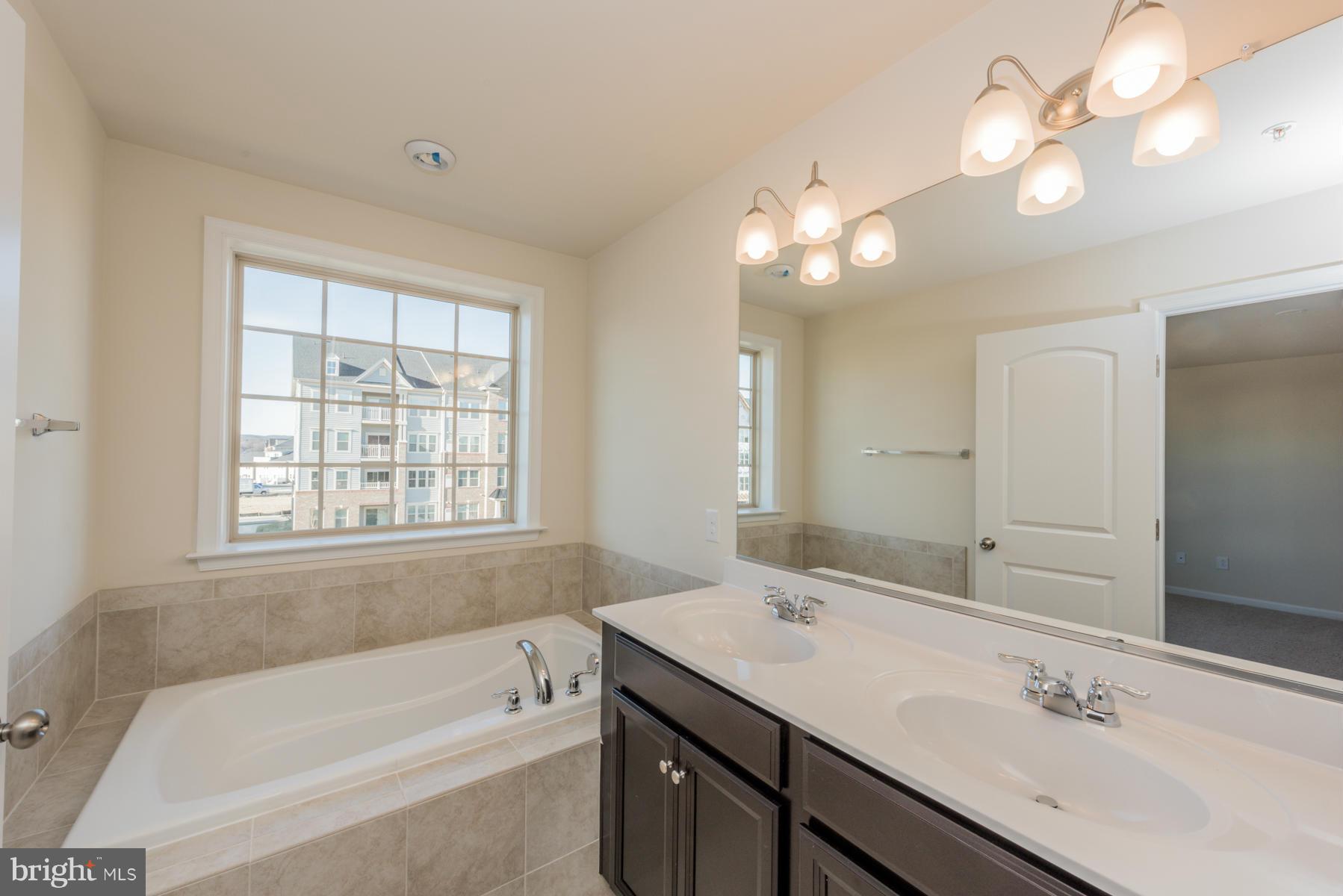 4716 Cambria Road Frederick, MD 21703 - Photo 20 of 27 a bathroom with a tub a sink and mirror