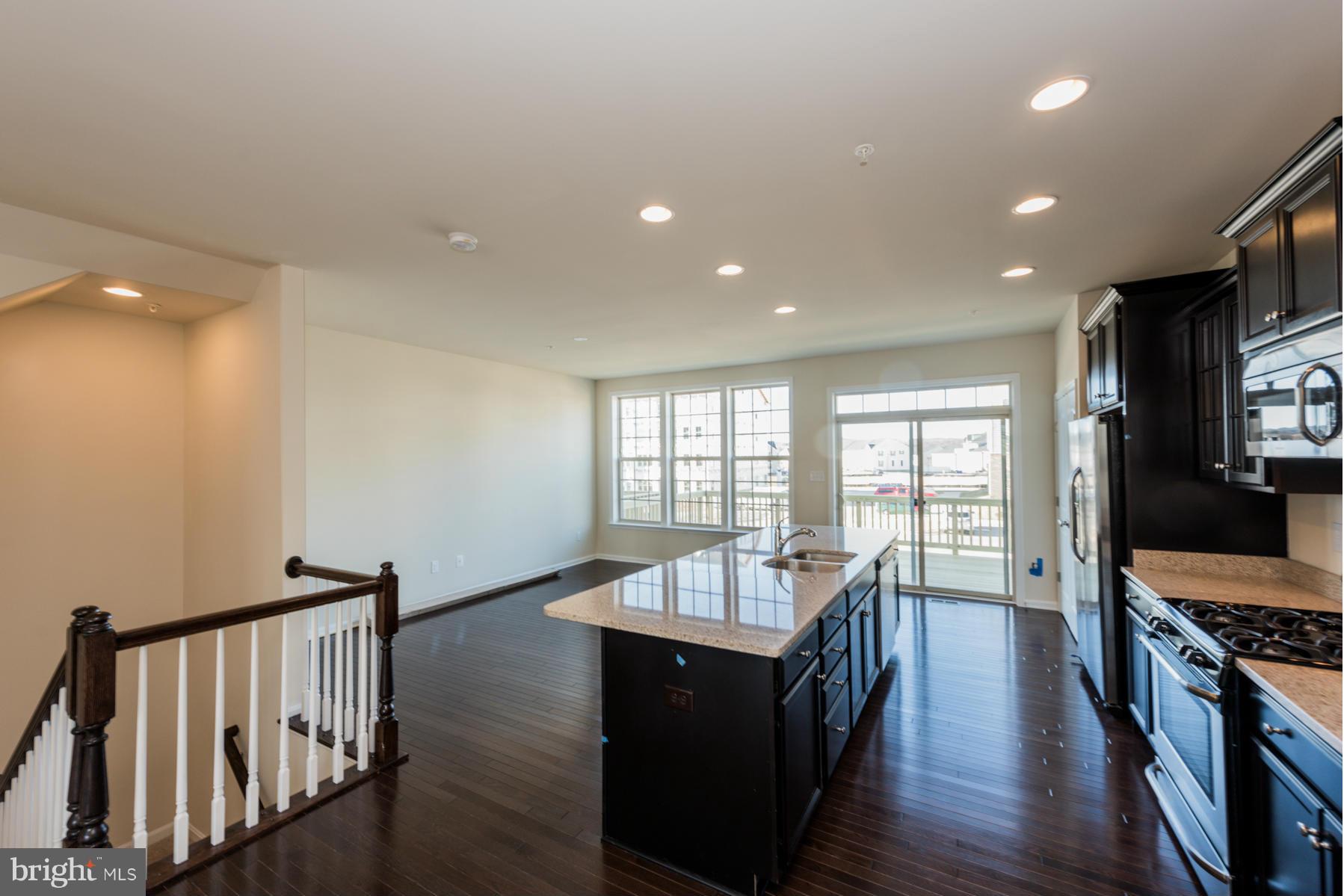 4716 Cambria Road Frederick, MD 21703 - Photo 8 of 27 a view of a dining room with furniture a ceiling fan and wooden floor