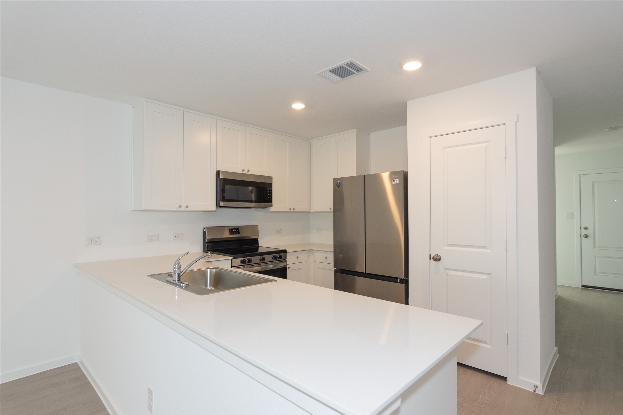 149 Star Packer Lane Jarrell, TX 76537 - Photo 9 of 30 A well-equipped kitchen features bright white cabinetry and sleek stainless steel appliances, creating a contemporary and functional space.