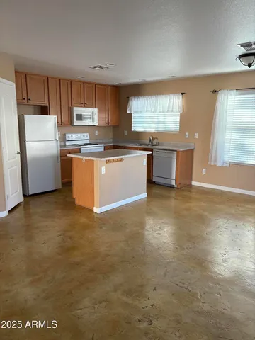 a kitchen with stainless steel appliances a refrigerator a sink a stove a microwave a counter space and cabinets