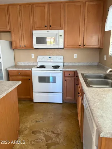 a kitchen with granite countertop a sink a stove and cabinets