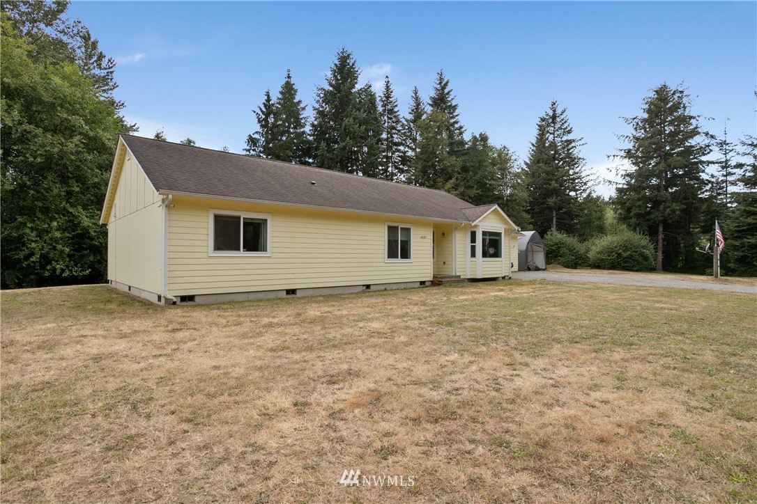4337 Maytown Road Southwest Olympia, WA 98512 - Photo 5 of 30 a backyard of a house with large trees and wooden fence