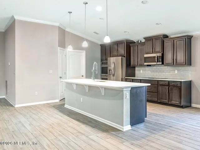 a kitchen with stainless steel appliances kitchen island wooden cabinets and granite counter tops
