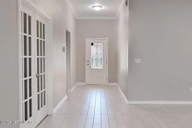a view of a hallway with wooden floor and a living room