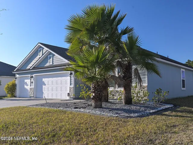 a front view of a house with a garden and yard